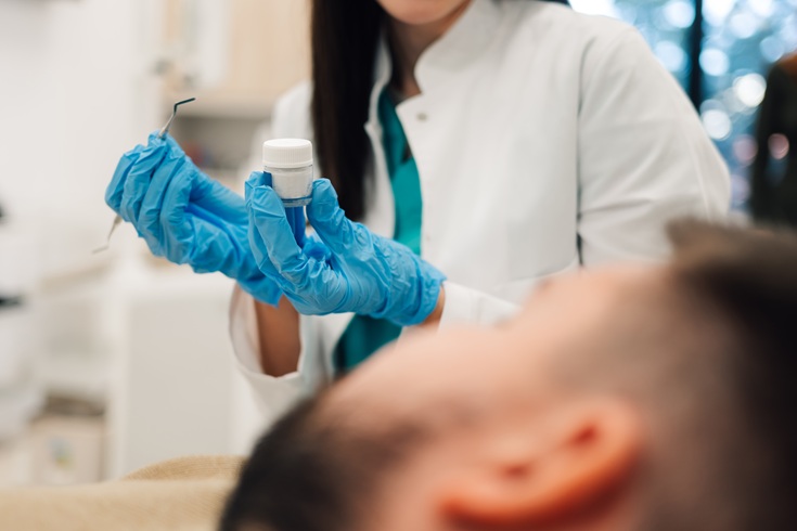 Dentist holding dental instruments and filling material getting ready for operation