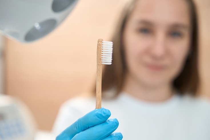 Woman dentist in dental office holds toothbrush in her hands