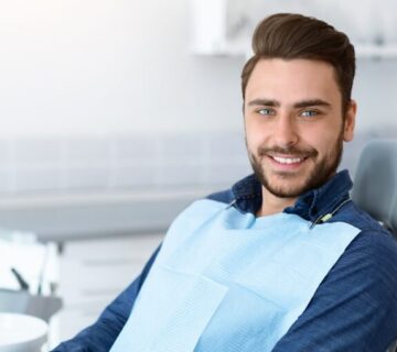 Young man patient smiling in dentistry, copy space