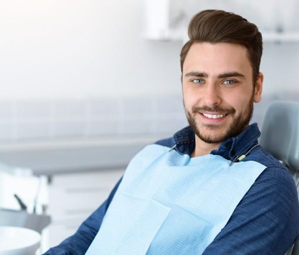 Young man patient smiling in dentistry, copy space