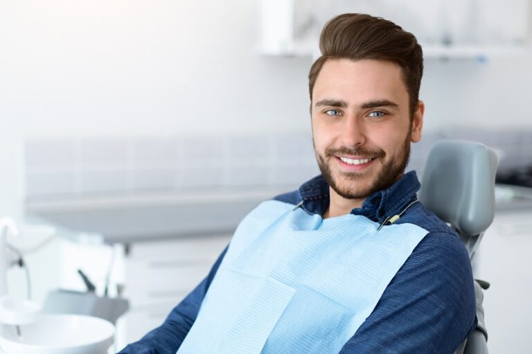Young man patient smiling in dentistry, copy space
